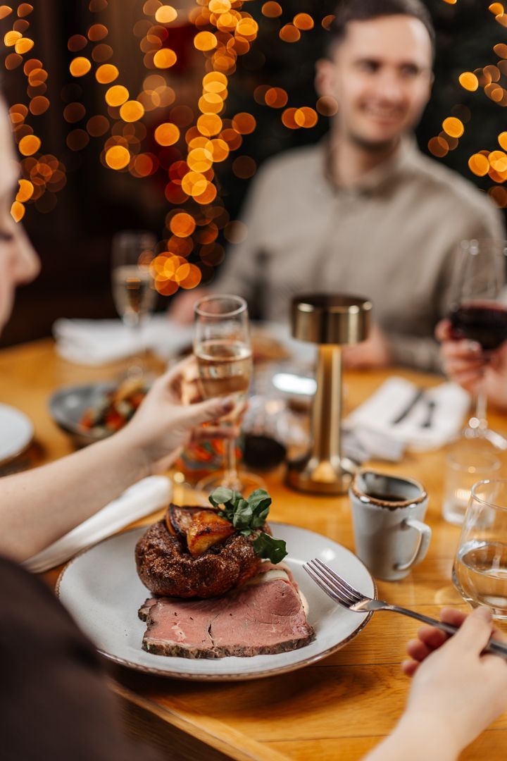 Lady raising a glass at Christmas meal