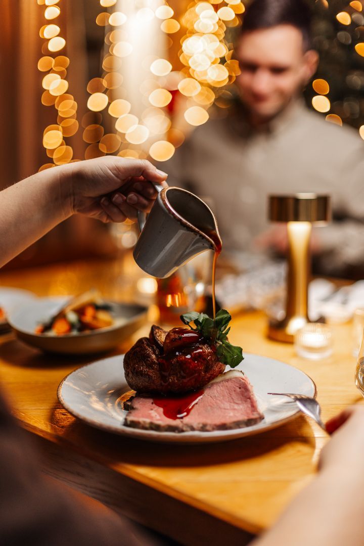 Gravy being poured over roast beef