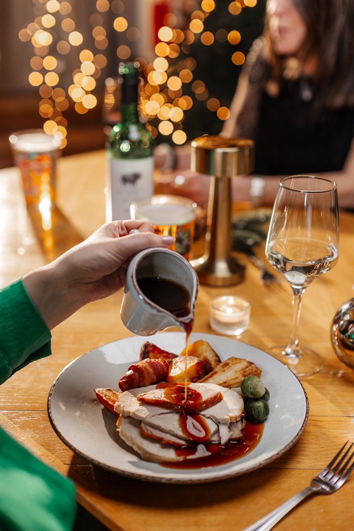 Gravy being poured on turkey dinner